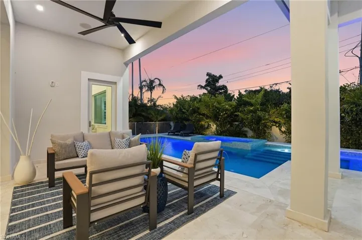 Pool at dusk with an outdoor hangout area, a patio area, and a fenced backyard