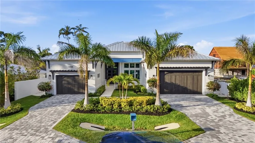 View of front of house with decorative driveway, stucco siding, and an attached garage