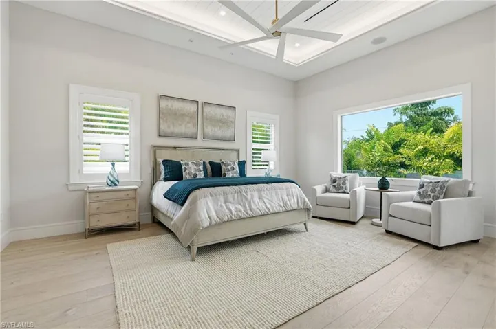 Bedroom featuring light wood-style floors, multiple windows, and a ceiling fan