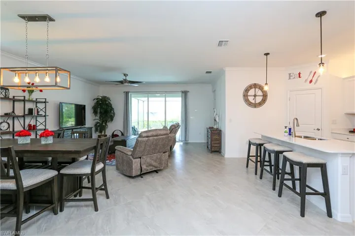 Dining room featuring ceiling fan, crown molding, and sink