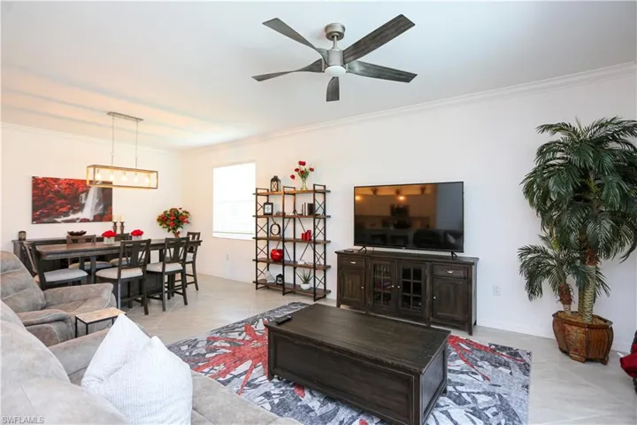 Tiled living room featuring ornamental molding and ceiling fan