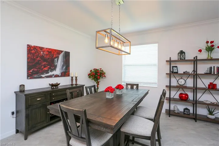 Dining space featuring crown molding and a chandelier