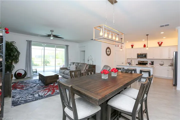 Dining space featuring crown molding, light tile patterned floors, sink, and ceiling fan