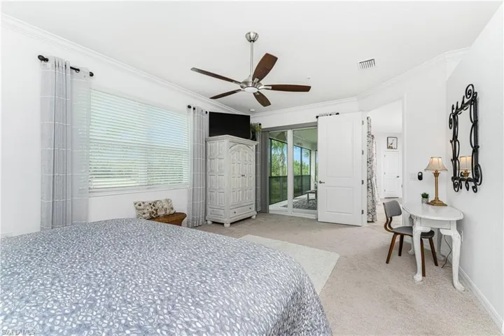 Carpeted bedroom with visible vents, ornamental molding, access to outside, baseboards, and ceiling fan