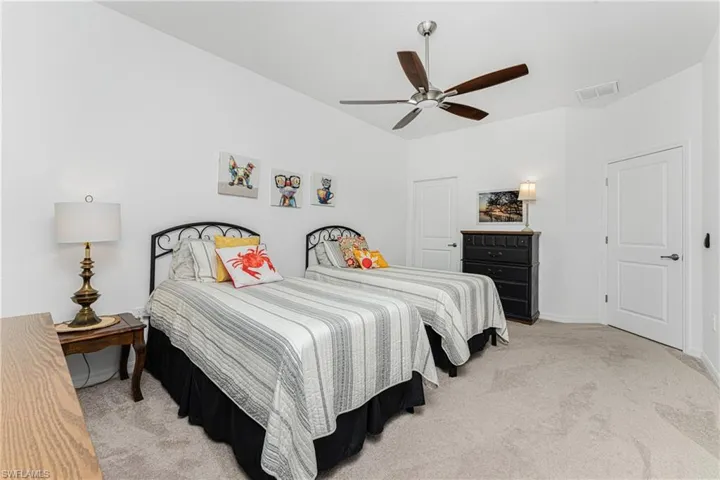 Bedroom with visible vents, carpet floors, baseboards, and a ceiling fan