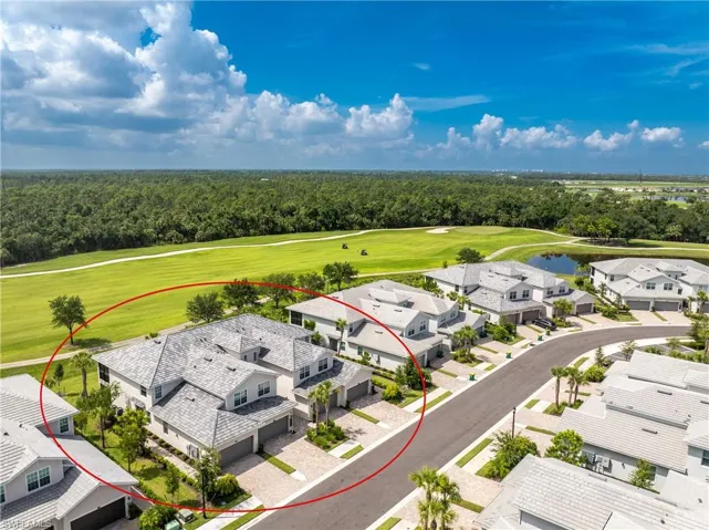 Drone / aerial view with golf course view, a view of trees, and a residential view