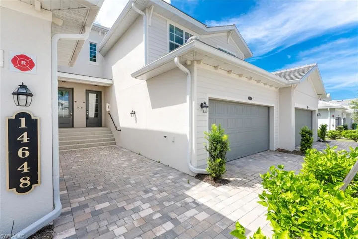 View of property exterior featuring decorative driveway, a garage, and stucco siding