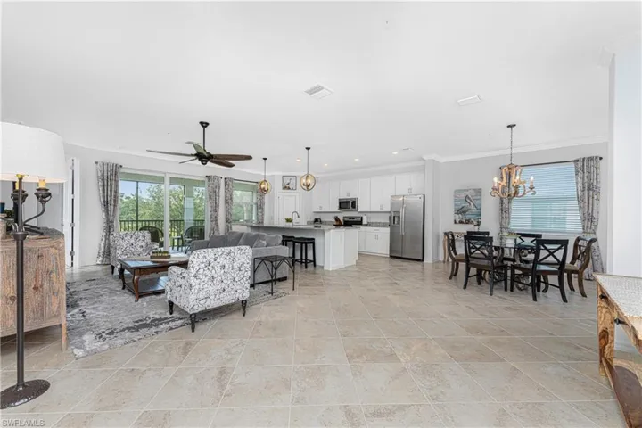 Living room with recessed lighting, ceiling fan with notable chandelier, visible vents, and ornamental molding