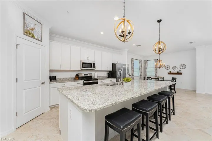 Kitchen with visible vents, an inviting chandelier, a sink, stainless steel appliances, and crown molding