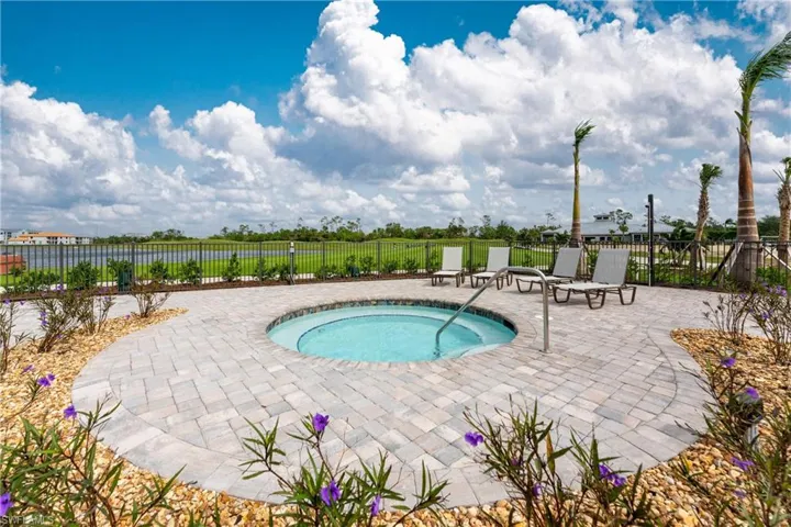 View of swimming pool featuring fence, a community hot tub, and a patio area