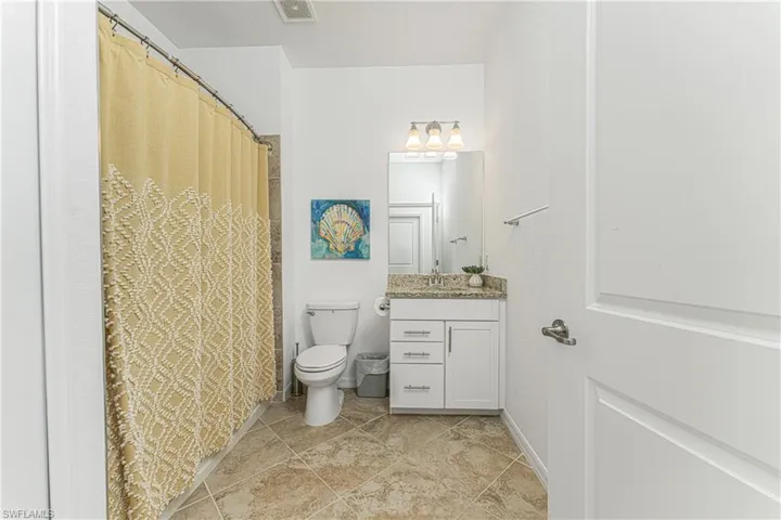 Full bath with visible vents, baseboards, toilet, and vanity