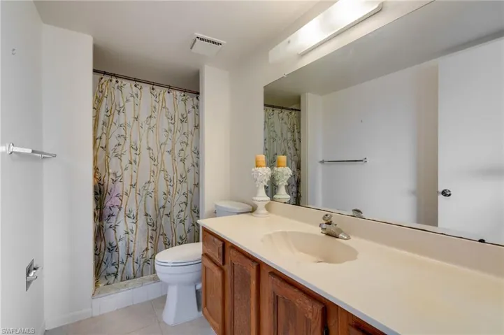 Bathroom with a shower with shower curtain, vanity, and light tile patterned flooring