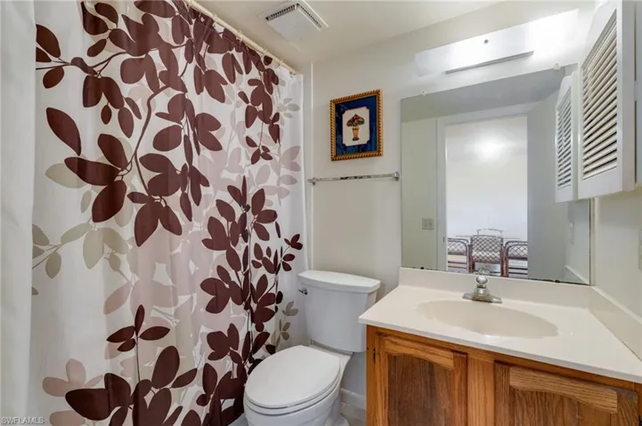 Bathroom featuring a shower with shower curtain and vanity