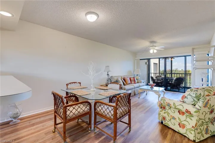 Dining space with light wood-type flooring, a textured ceiling, and a ceiling fan