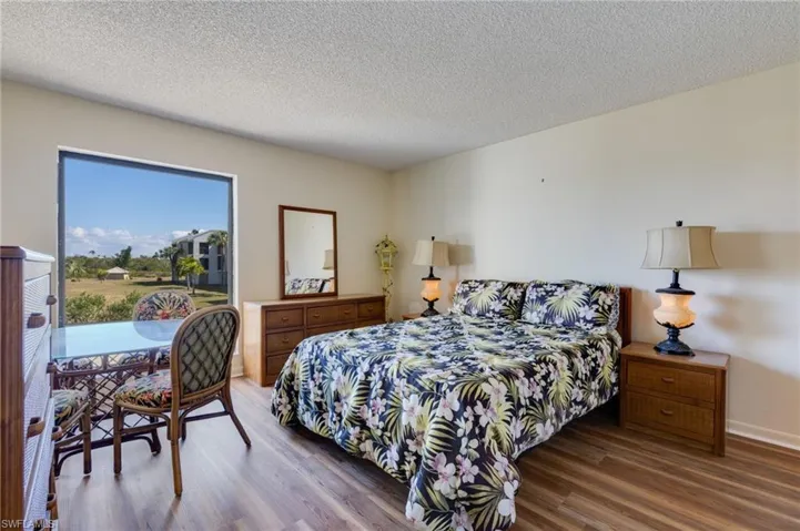 Bedroom with wood finished floors and a textured ceiling