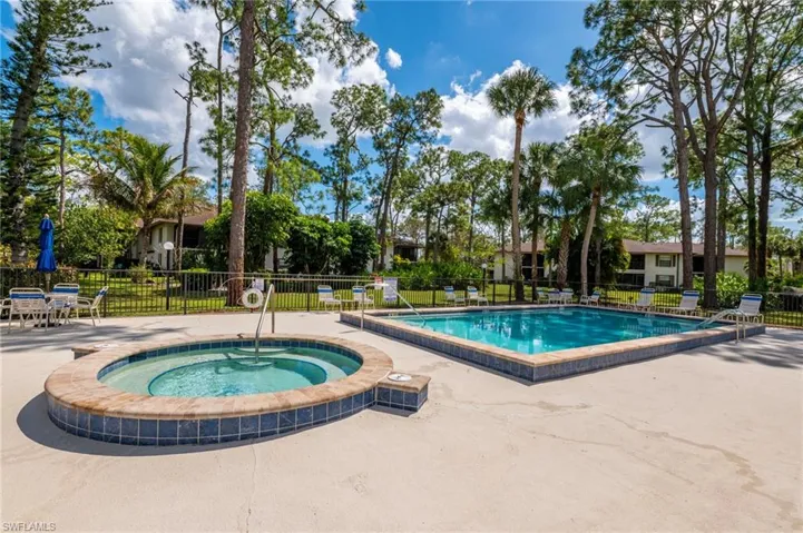 Community pool with a patio and a hot tub