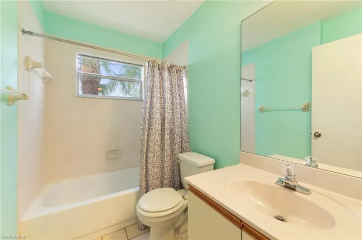 Bathroom featuring vanity, shower / bath combo, and tile patterned floors