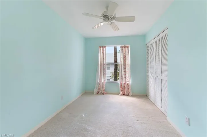 Unfurnished bedroom with light colored carpet, a ceiling fan, and a closet
