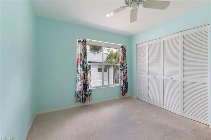 Unfurnished bedroom featuring light colored carpet, ceiling fan, and a closet