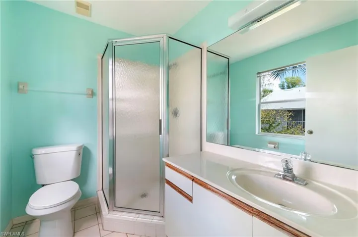 Bathroom with vanity, light tile patterned flooring, and a shower stall