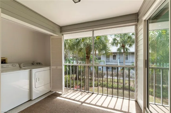 Laundry area on lanai, with light colored outdoor carpet, independent washer and dryer, and plenty of natural light