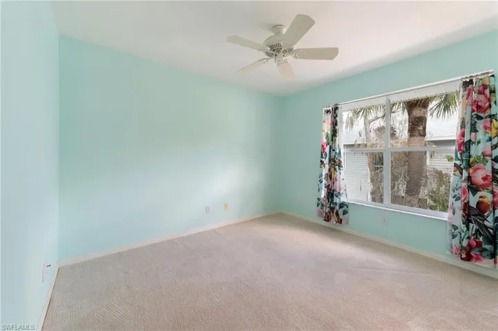 Spare room featuring carpet and ceiling fan