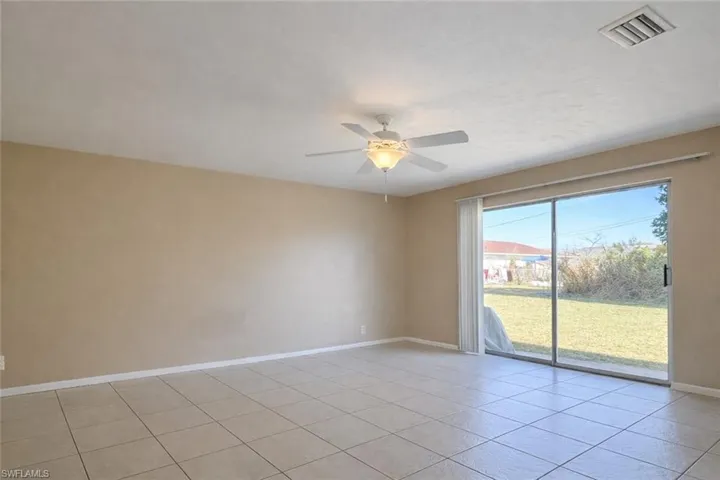 Empty room featuring light tile patterned floors and ceiling fan