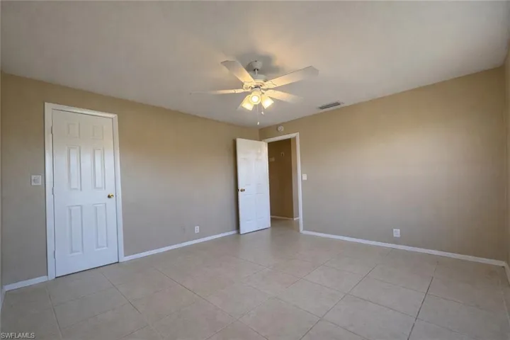 Unfurnished bedroom featuring a ceiling fan and light tile patterned floors