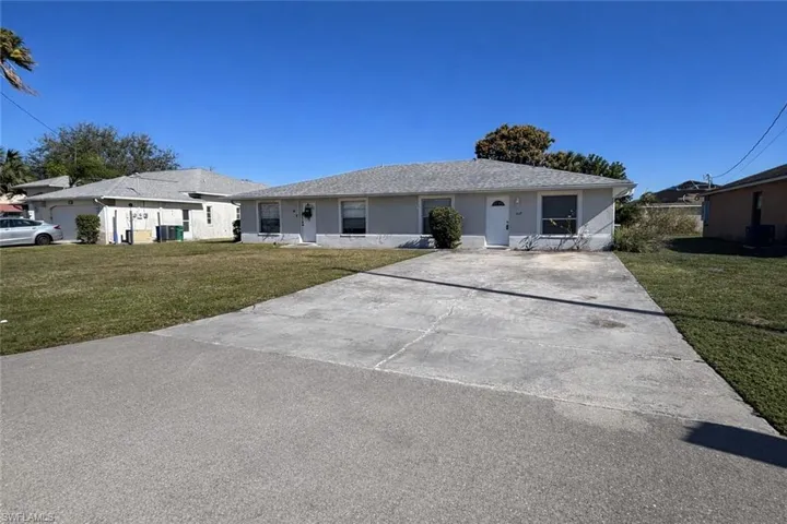 Ranch-style home with a front lawn, concrete driveway, and roof with shingles