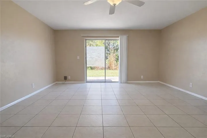 Unfurnished room with light tile patterned floors and ceiling fan