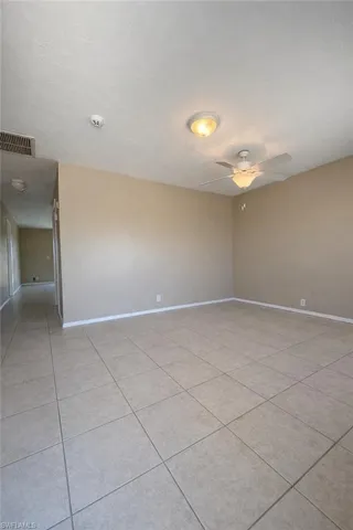 Unfurnished room featuring ceiling fan, light tile patterned floors, and a textured ceiling