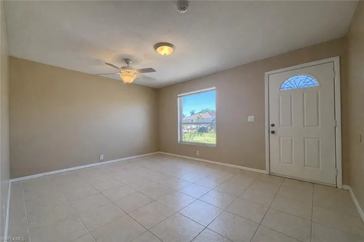 Foyer entrance featuring light tile patterned flooring and ceiling fan