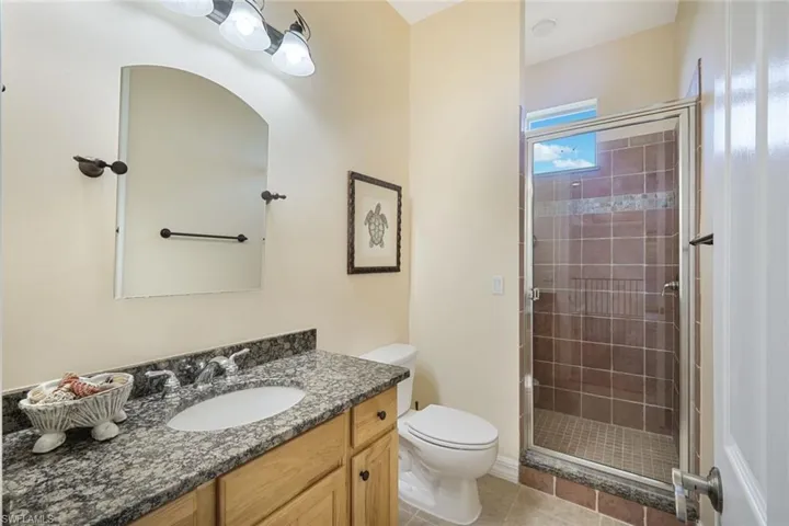 2nd level guest bathroom with granite countertop and walk-in shower