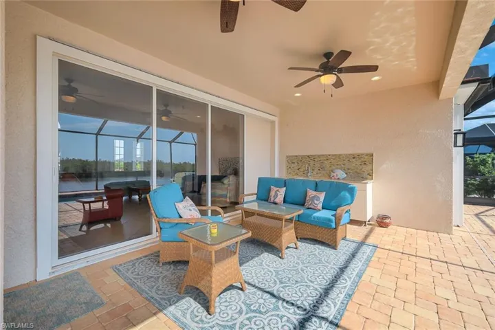 Lanai area with outdoor kitchen with sink, cabinet and refrigerator and room for a grill.