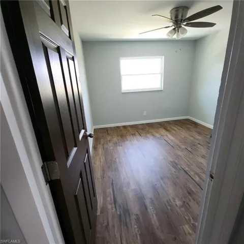 Empty room featuring ceiling fan and hardwood / wood-style flooring