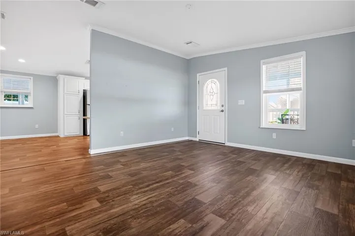 Entryway with Crown molding and dark wood finished floors