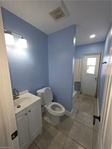 Full bathroom with vanity, light tile patterned floors, a shower, and recessed lighting