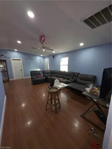 Living area featuring ceiling fan, dark wood-style floors, and recessed lighting