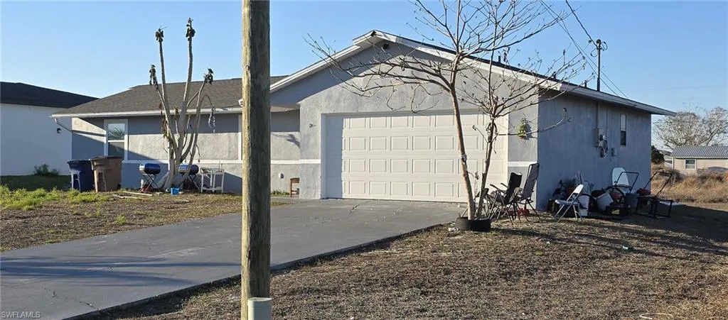 View of home's exterior with driveway, an attached garage, and stucco siding