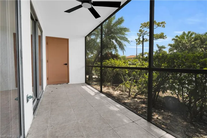 Screened patio with tile flooring, featuring a ceiling fan and direct access to the interior via sliding glass doors