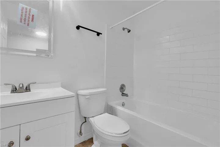 Bathroom featuring a white vanity with integrated sink, chrome faucet, and a toilet