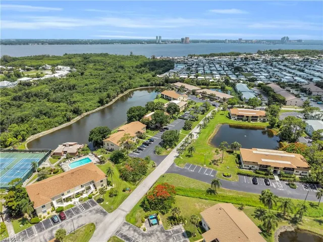 Aerial perspective showcasing multiple residential buildings, two distinct bodies of water, and extensive green spaces