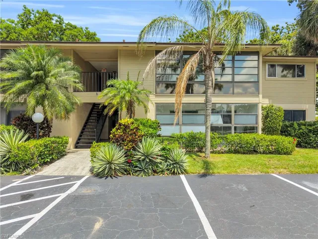 Exterior multi-story property featuring a contemporary design with expansive window arrays, a private balcony with metal railing, and an exterior staircase