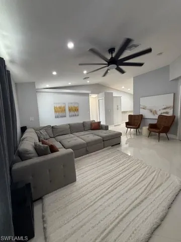 Living room featuring vaulted ceiling, ceiling fan, and recessed lighting