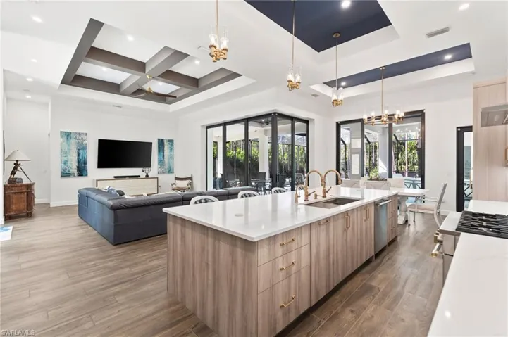 The chef’s kitchen boasts quartz countertops with a matching backsplash, an oversized eat-in island, driftwood-style cabinetry with champagne fixtures.