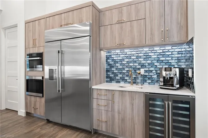 Miele & Monogram appliances, a walk-in pantry, and an adjacent wet bar with wine fridge.