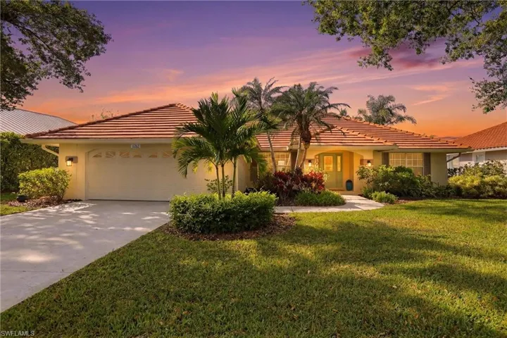 Mediterranean / spanish home featuring a garage, stucco siding, a tile roof, and driveway