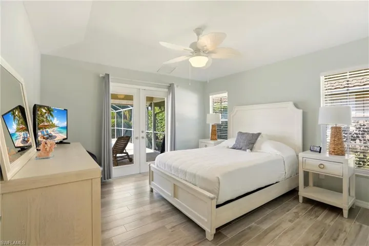 Bedroom featuring french doors, light wood-style floors, access to exterior, and ceiling fan