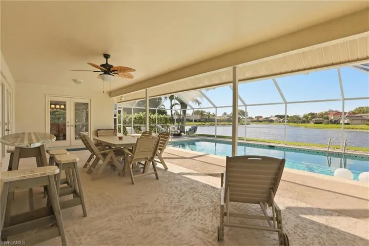 Outdoor pool featuring french doors, a patio, a sunroom, a lanai, and outdoor dining space