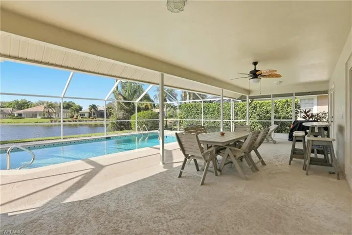 Swimming pool featuring a patio area, a lanai, a sunroom, outdoor dining space, and a residential view